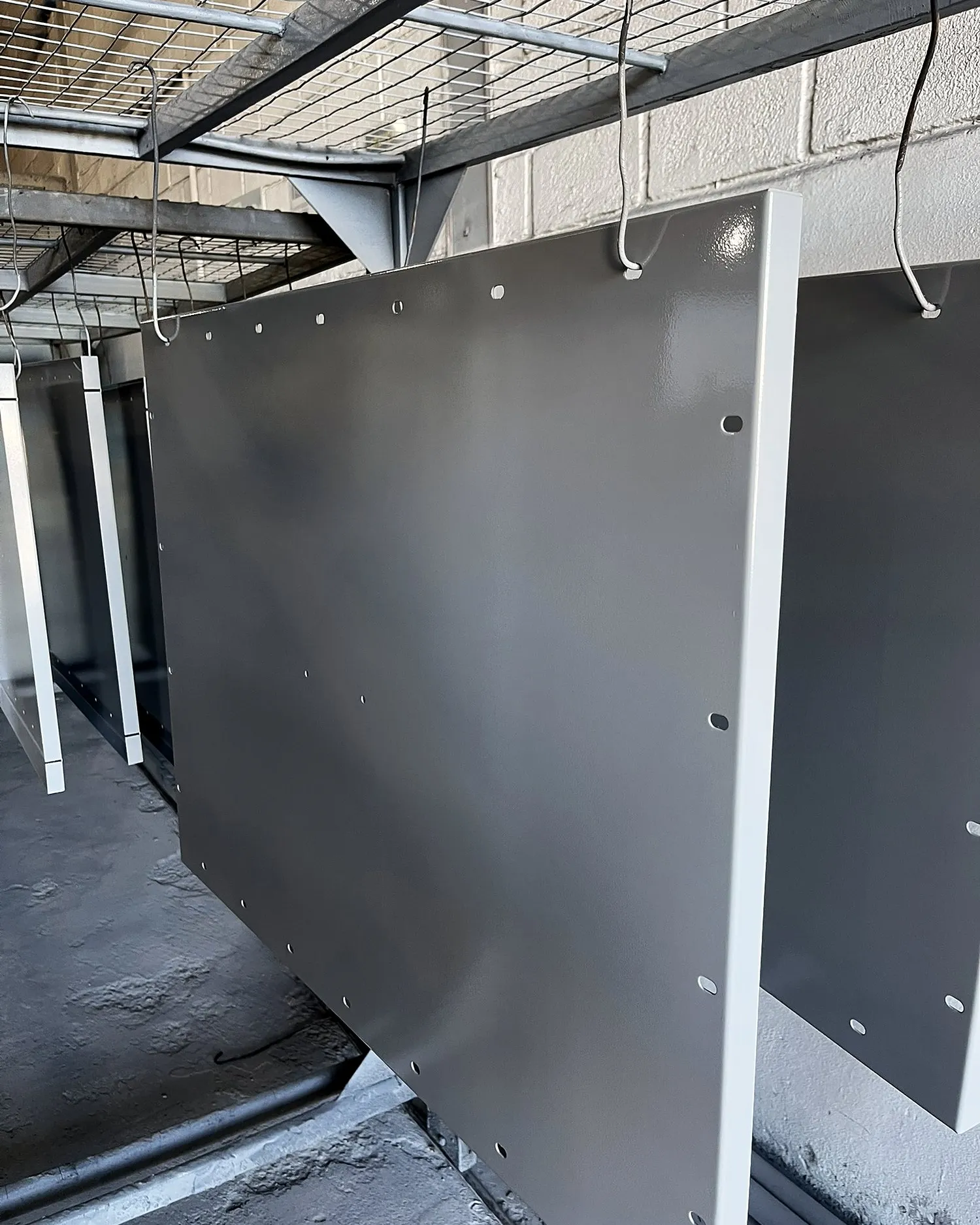 Gabinete metálico cinza Munsell N 6,5 pendurado na linha de pintura