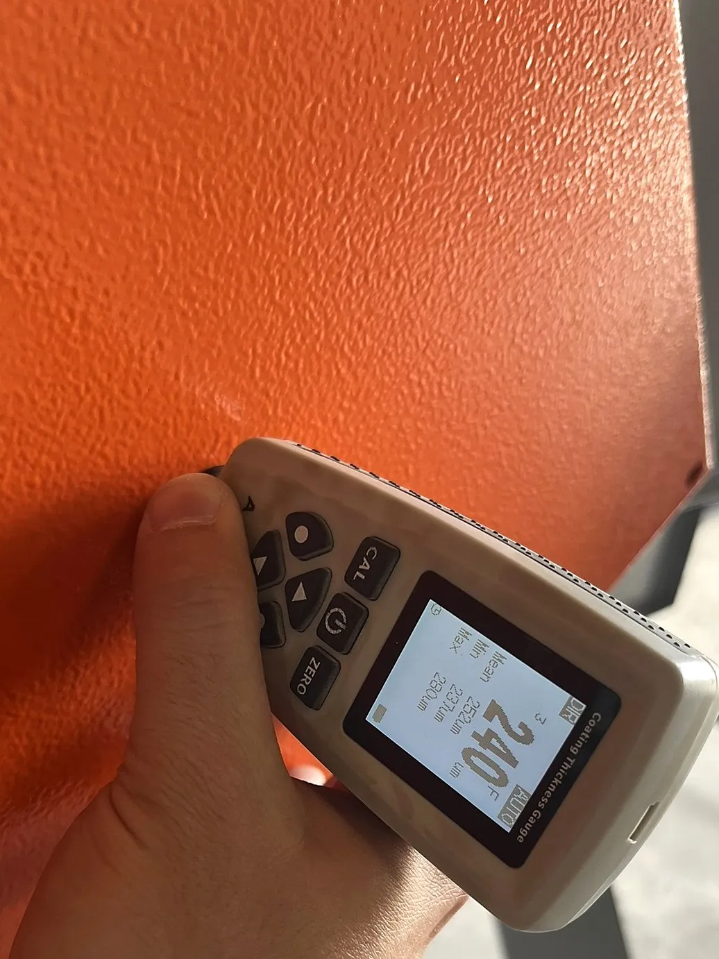 Medição de camada em peça laranja, leitura de 240 µm em sistema de duas demãos